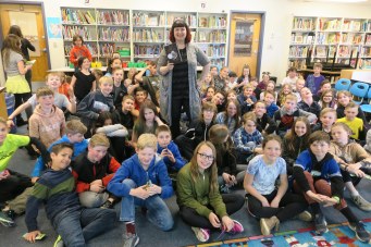 The author with grade 5 and 6 students in their school library
